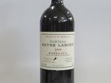 the bottle of red wine is sitting on a white surface