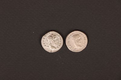 a close up of two silver coins on a black surface