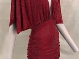un mannequin vêtu d'une robe rouge recouverte d'une cape