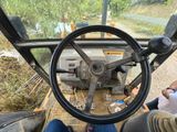 a man sitting in the driver ' s seat of a tractor