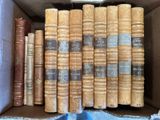de nombreux livres anciens dans une boîte posée sur un tissu bleu