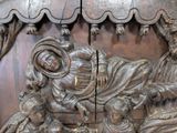 a wooden carving of a man and a woman on a bench