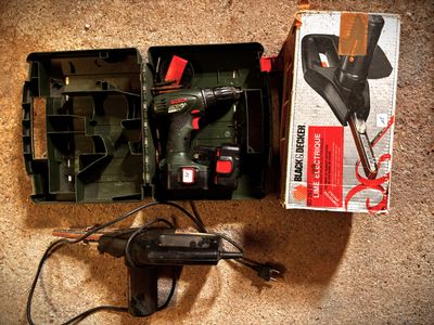 a box with a drill and a cord in it on the floor
