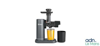 an image of a juicer with a glass of orange juice next to it