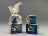 two mugs and a bag of treats are sitting on a table