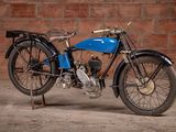 a blue motorcycle that is parked in front of a brick wall