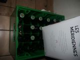 bottles of beer in a green crate next to a box of medicine