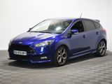 Une Ford Focus bleue est garée dans une pièce dont le sol est à carreaux.