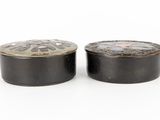 pair of black and white tinned boxes on a white surface