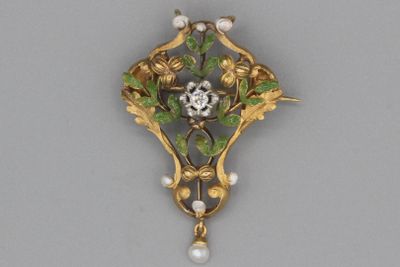 une image représentant une broche ornée de perles et de fleurs