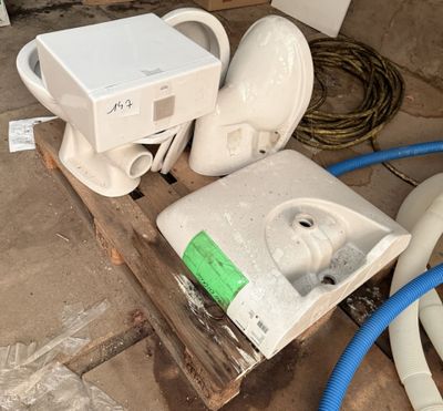 deux toilettes posées sur une palette au milieu de la pièce