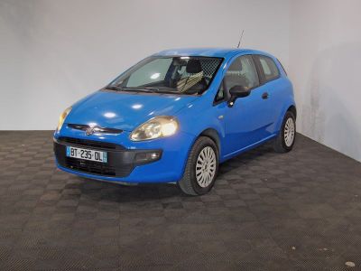 the small blue car is parked in a large room