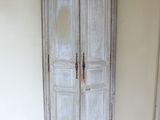 un coin d'une pièce avec un parquet et une armoire blanche