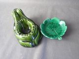 a green vase and a green leaf shaped bowl on a table