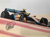 photo dédicacée d'une voiture de course sur un circuit, avec le ciel en arrière-plan