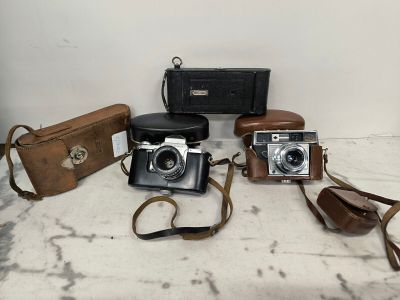 a lot of different types of cameras sitting on a table