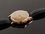 a close up of a watch on a black leather strap
