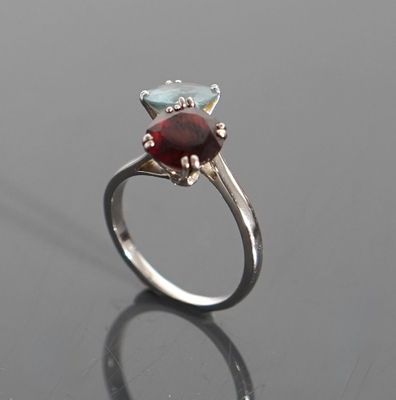an image of a ring with a garnetite and a blue topazt stone