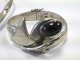 a silver bracelet with a purple stone on it