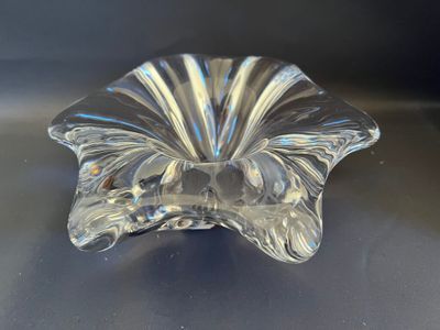 bol en verre transparent en forme de fleur posé sur un socle noir