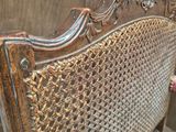 a wooden bench that has a wicker seat on top of it