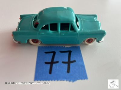 une petite voiture verte posée sur une feuille de papier bleue