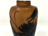 un vase marron orné d'un oiseau sur un fond blanc