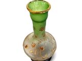 a green vase with a gold rim sitting on a white surface