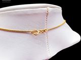 a gold choke with a chain on a mannequin neck