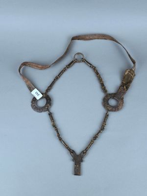 un vieux collier auquel est suspendue une clé, autour de son cou