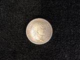 a close up of a silver coin on a black surface