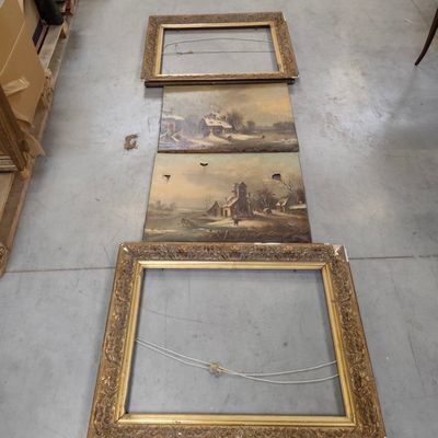 several framed paintings on the floor in a room