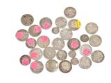 un tas de pièces d'argent sur lesquelles sont collés des autocollants roses