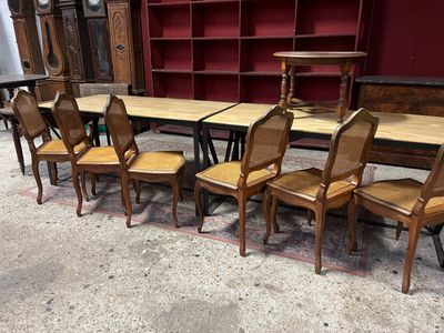 Des tables et des chaises sont alignées dans une pièce aux murs rouges.