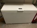 a white chest freezer sitting on the floor in a room