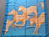 foulard en soie bleu et orange orné de zèbres et de girafes