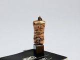 une petite statue représentant une personne enroulée dans une corde