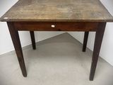 une vieille table en bois surmontée d'un petit tiroir