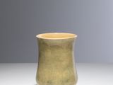 une image représentant une tasse verte posée sur une table blanche