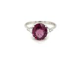 a close up of a pink sapphire and diamond ring on a white background