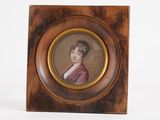 une vieille photo d'une femme en robe rose, dans un cadre en bois