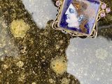 un gros plan sur le portrait d'une femme représenté sur une broche de forme carrée