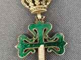 une croix verte surmontée d'une couronne