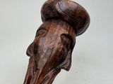 a wooden sculpture of a bird with a hat on it ' s head