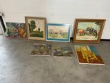 many paintings on the floor in a room