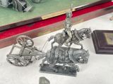 a silver statue of a man on a horse drawn carriage