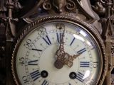 a gold clock with roman numerals on the face