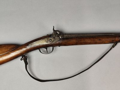 un vieux fusil avec une crosse et un canon en bois