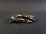 a bronze statue of a woman laying on her stomach