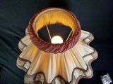 a lamp that is sitting on a table with a cell phone